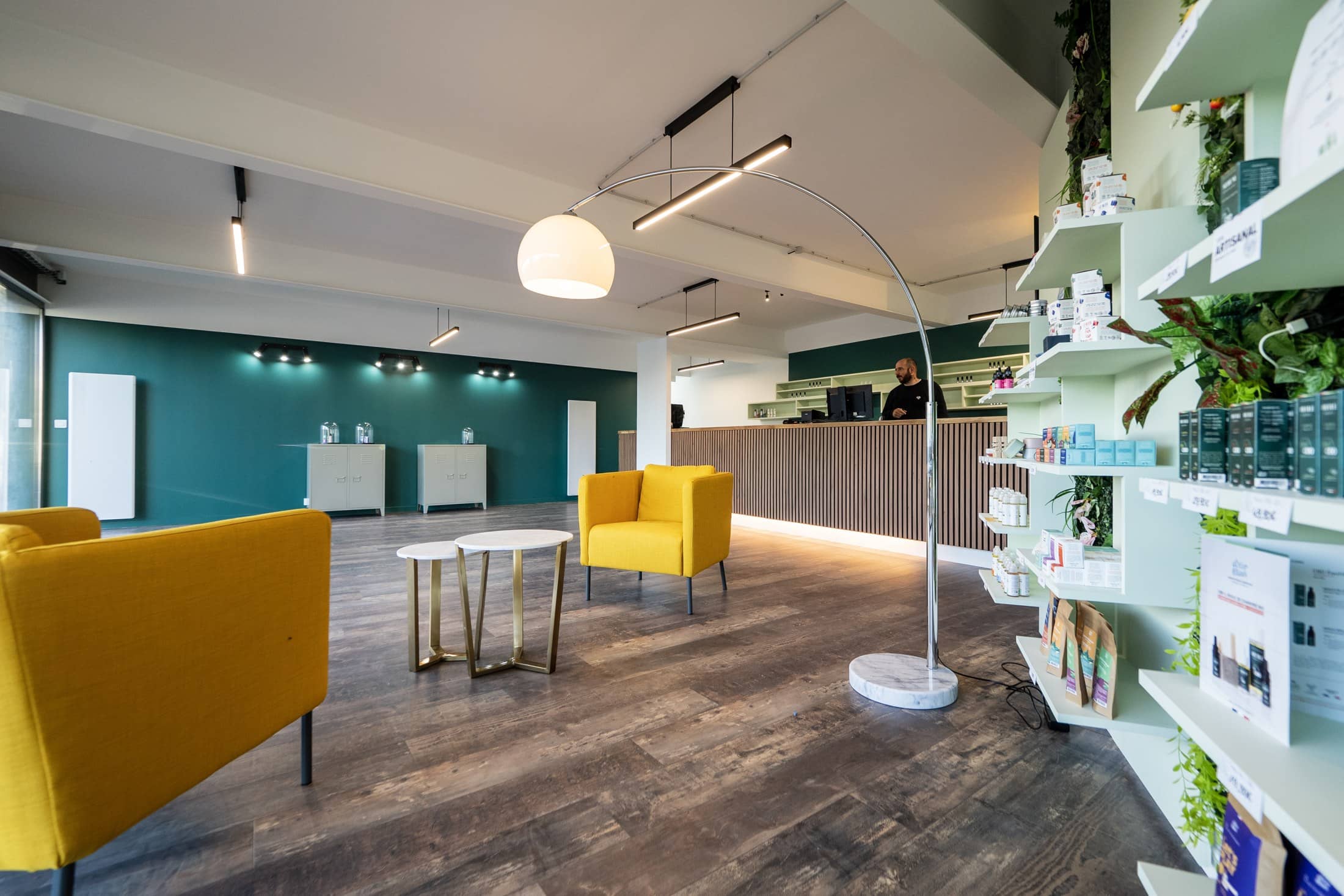 L’intérieur de la boutique Vape & Conseil : fauteuils moutarde, comptoir en bois clair et rayonnages d’e-liquides.